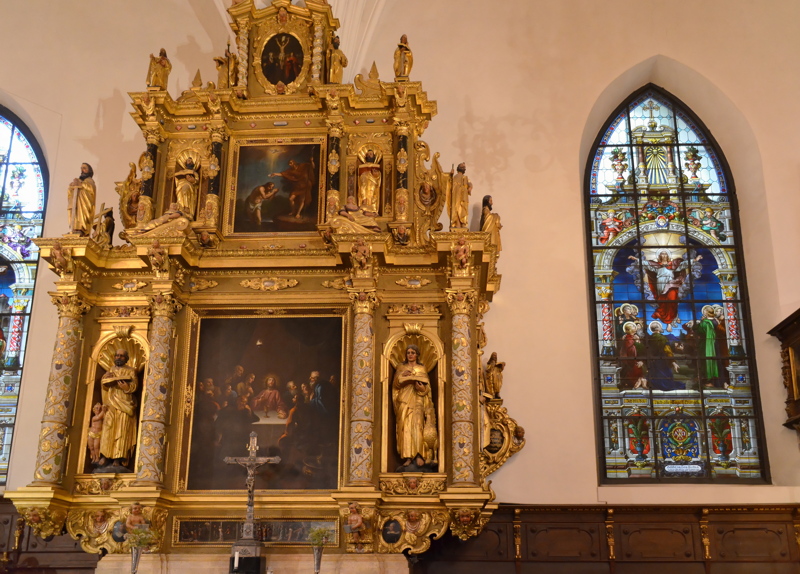 28 - The ornate gold-leafed altar and a tall stained glass window inside the German Church in Stockholm